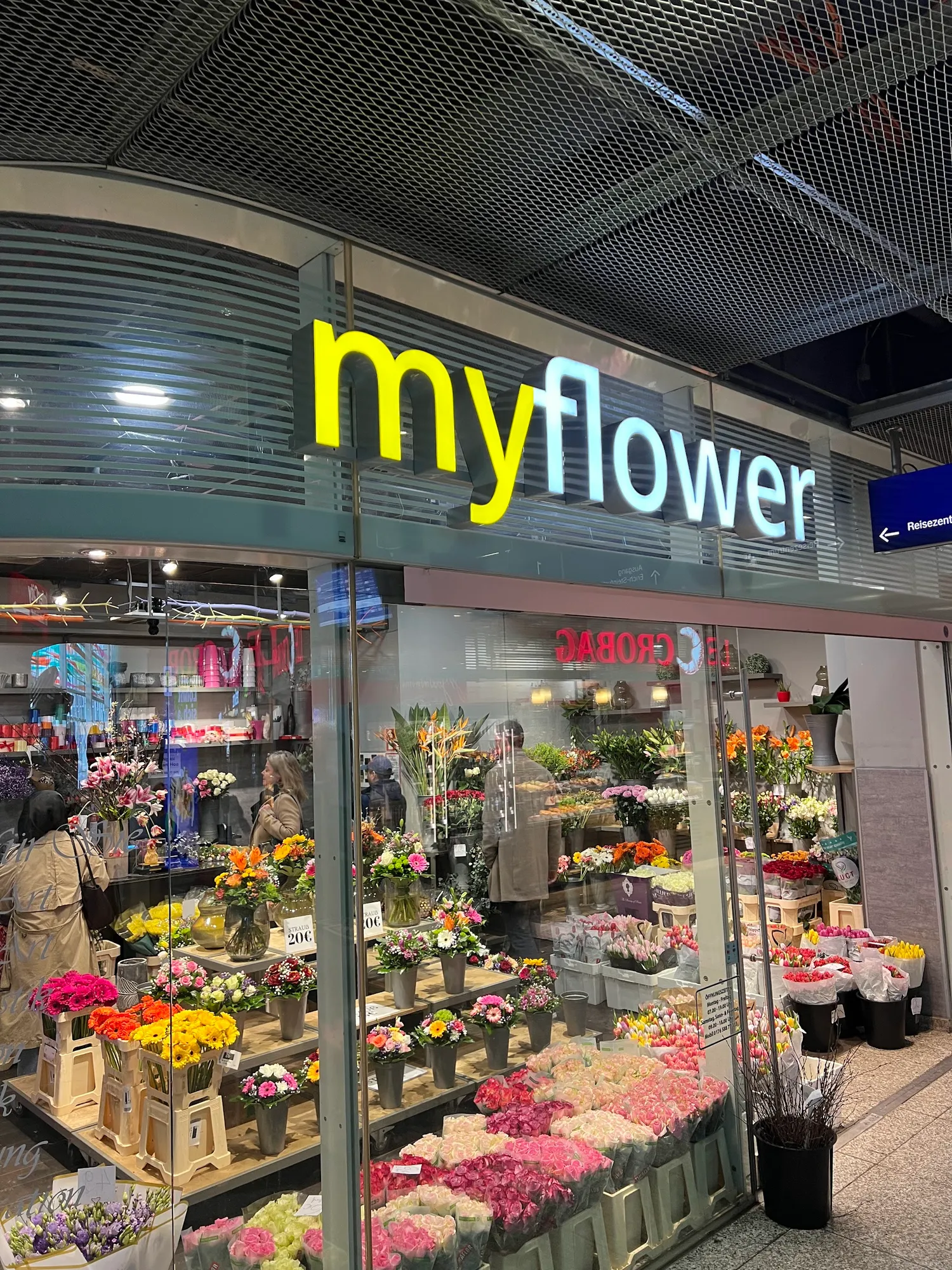 Der Laden My Flower im Ostbahnhof: leuchtender Schriftzug über dem Schaufenster, davor Eimer voller Blumen