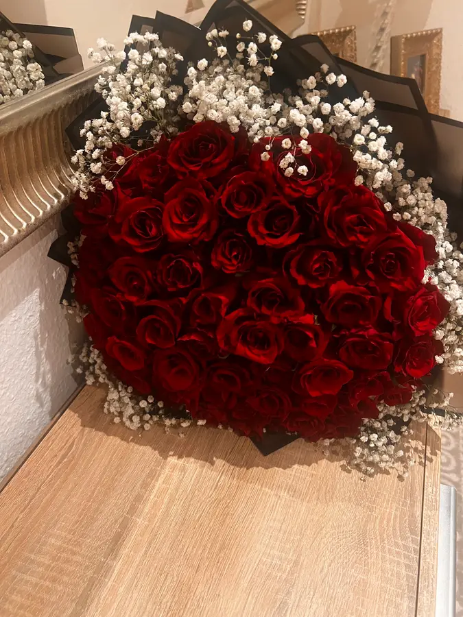 Herzförmiges Meer aus roten Rosen mit Schleierkraut-Rand